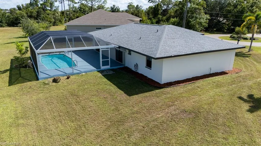 Aerial view showcasing the spacious lot and screened-in pool.