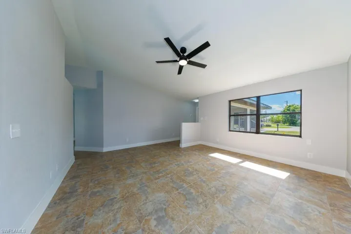 Living area with soaring lofted ceiling and a ceiling fan to enhance airflow.