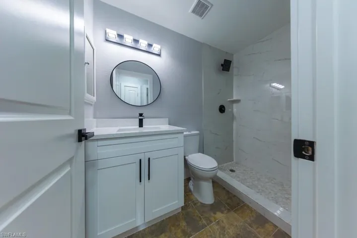 Bright and modern second bathroom with sleek fixtures, contemporary lighting, and a walk-in shower for added convenience.