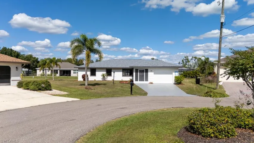 Ranch-style curb appeal with a green front lawn and shingled roof.