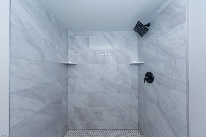 Beautifully updated ensuite bathroom featuring a walk-in shower with modern tile surround, sleek vanity with ample storage, and contemporary finishes throughout.