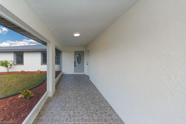 Inviting front entry with charming stucco finish and sunny patio appeal.