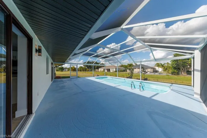 Expansive covered patio in a brand-new screened enclosure, ideal for lounging or entertaining.