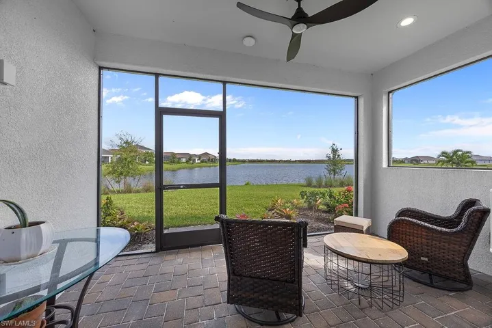 Sunroom featuring a textured wall, a water view, and recessed lighting