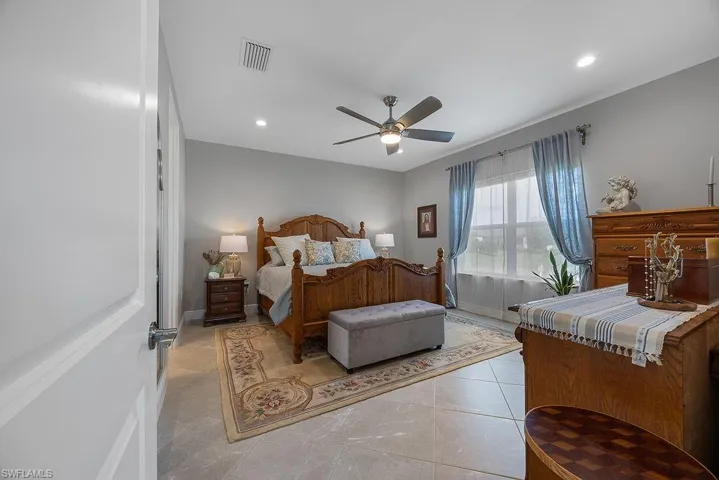 Bedroom with recessed lighting, light tile patterned floors, and ceiling fan