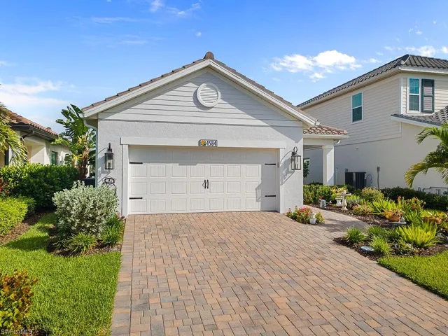 View of front of house featuring decorative driveway, an attached garage, and stucco siding