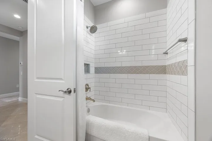 Full bath with shower / bathtub combination and baseboards