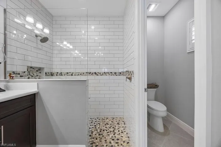 Full bathroom featuring walk in shower, vanity, and light tile patterned floors