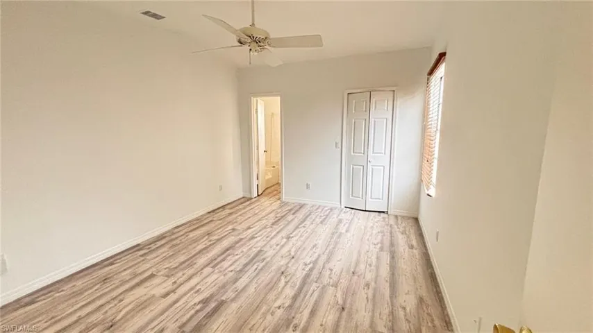 Unfurnished bedroom featuring light wood finished floors, ceiling fan, and a closet
