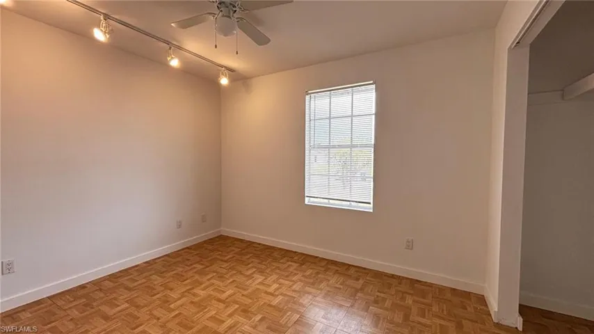 Empty room with track lighting and a ceiling fan