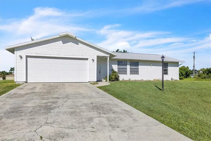 Ranch-style house with driveway, a front yard, and a garage