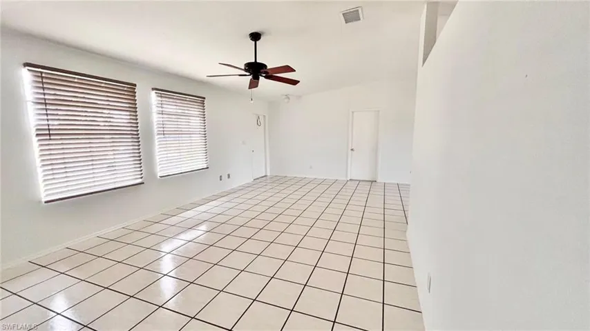 Empty room featuring light tile patterned floors and ceiling fan