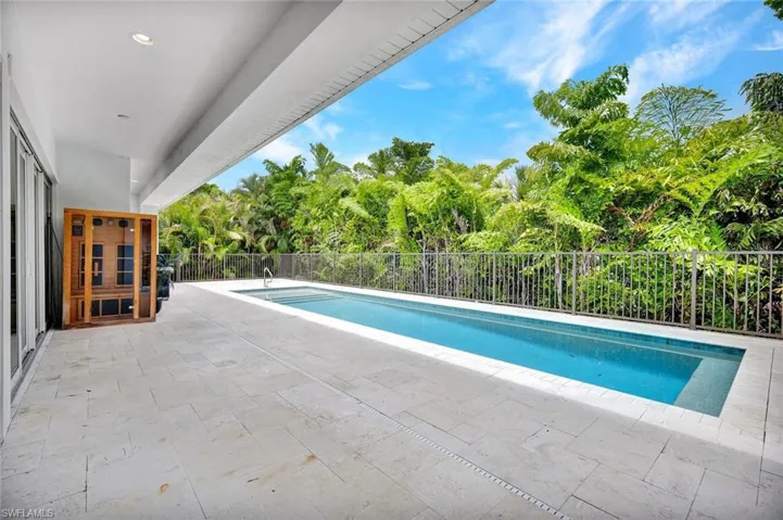 Pool deck features travertine tile.