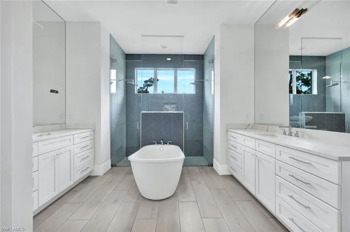 Primary bathroom features a large soaking tub and a walk-in shower with dual shower heads.