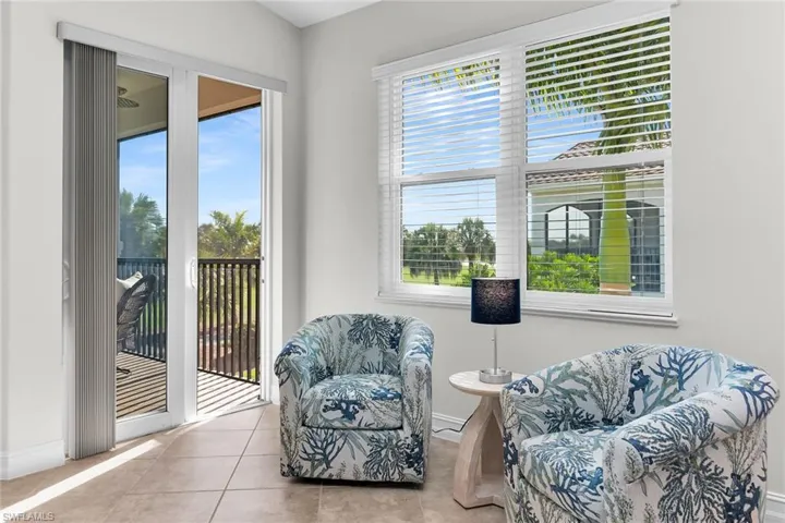 Light-filled living area with large windows, neutral finishes, and direct access to the lanai, offering tranquil outdoor views.