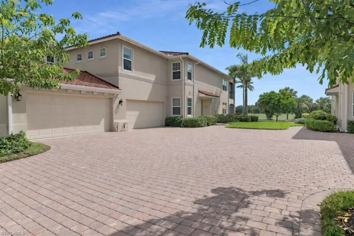 Mediterranean / spanish-style house featuring stucco siding, decorative driveway, and a garage.