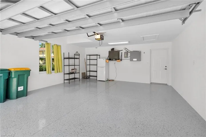 Two car garage featuring epoxy flooring and overhead storage.