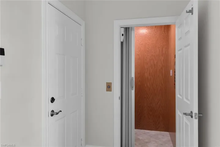 Private elevator featuring wood paneled interior and tile flooring.