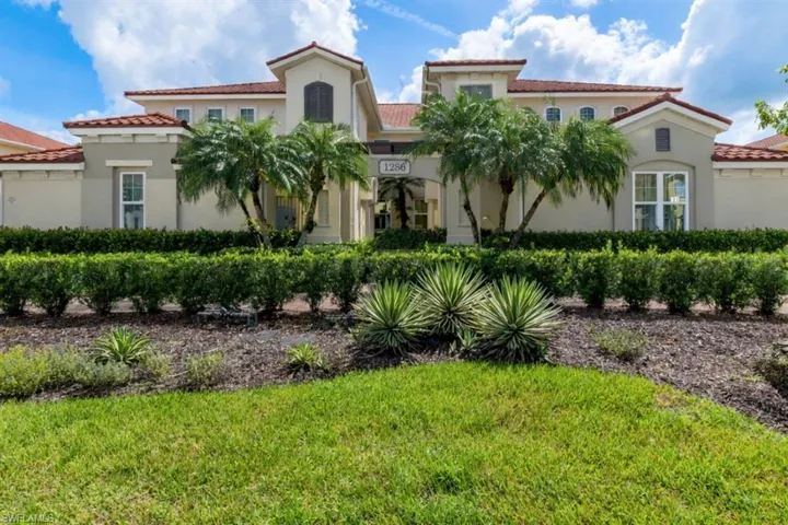 Exterior of an elegant Mediterranean-style residence with updated neutral façade and lush tropical setting.