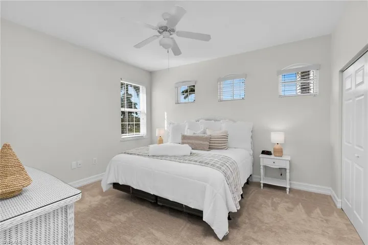 Third bedroom with light colored carpet and a ceiling fan.