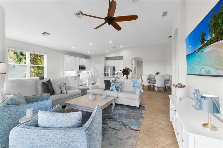 Expansive great room with vaulted ceilings, recessed lighting, and open-concept design connecting the living area, dining space, and updated kitchen.