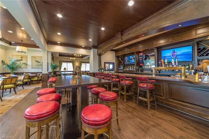 Inside, enjoy an air-conditioned English-style pub featuring ornamental molding, wooden ceiling, recessed lighting, and hanging light fixtures.