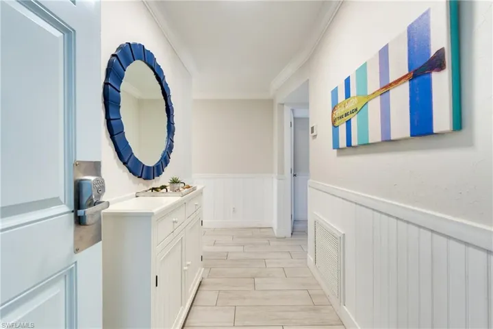 Bathroom featuring wainscoting, ornamental molding, wood finish floors, and vanity