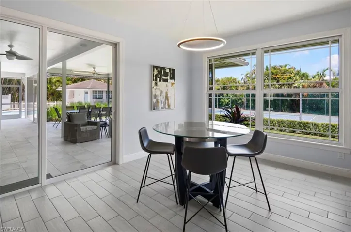 Dining area featuring light wood-finish flooring and a contemporary circular pendant light