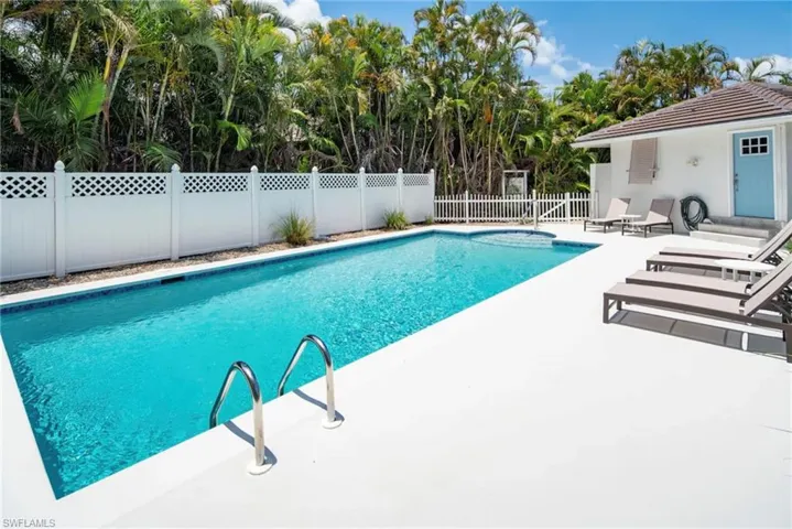 Rectangular swimming pool with integrated spa and white coping