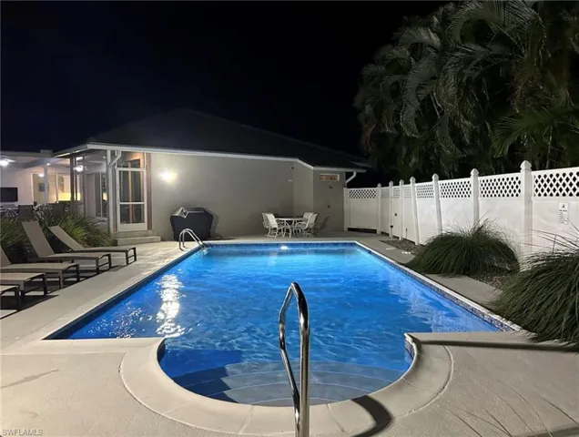 Rectangular swimming pool featuring integrated steps and a stainless steel handrail