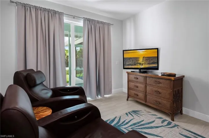 Sliding glass doors featuring exterior access, light-toned wood-finish flooring, and crisp white baseboards