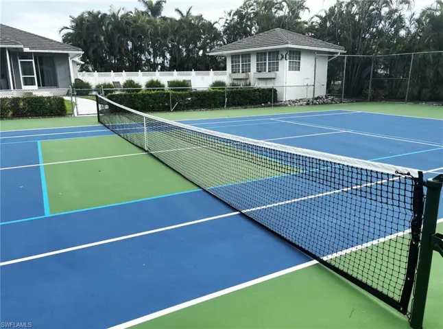 Regulation-sized tennis court featuring blue and green playing surfaces with a net