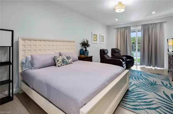 Spacious bedroom featuring light wood-finish flooring and recessed lighting