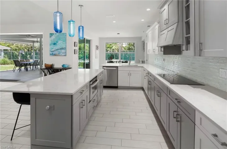 Open-concept kitchen featuring light-toned wood-finish flooring and a spacious center island with seating