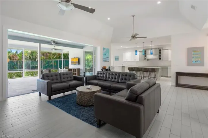Vaulted ceilings complement the open-concept living space with light-toned wood-finish flooring