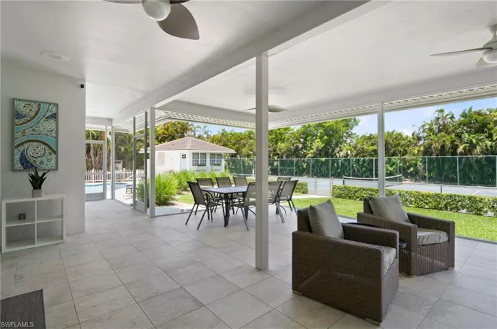 Expansive screened patio featuring tile flooring and ceiling fans