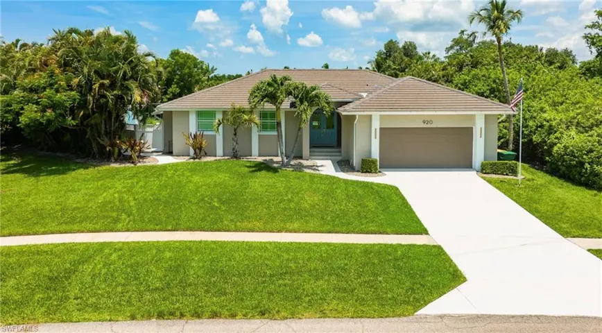 Single-story residence featuring a tile roof, light stucco exterior, and an attached two-car garage with a brown door