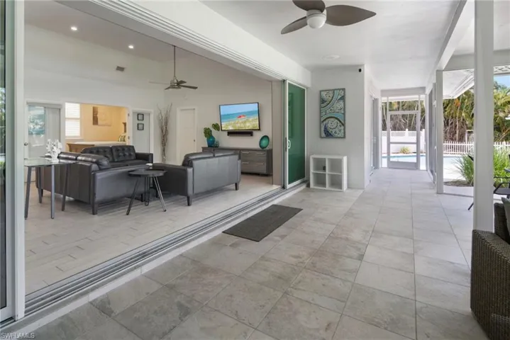 Covered outdoor patio featuring light-toned tile flooring and a ceiling fan