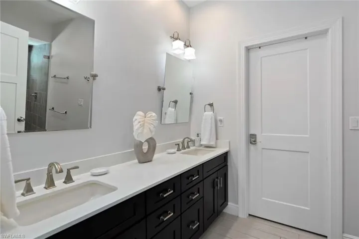 Dual vanity featuring undermount sinks, brushed nickel fixtures, and a light-toned countertop