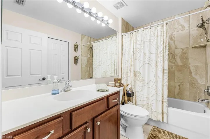 Guest bathroom offer tub/shower combination and large vanity.