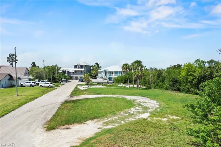 Expansive grass lot with mature trees, offering a clear development opportunity