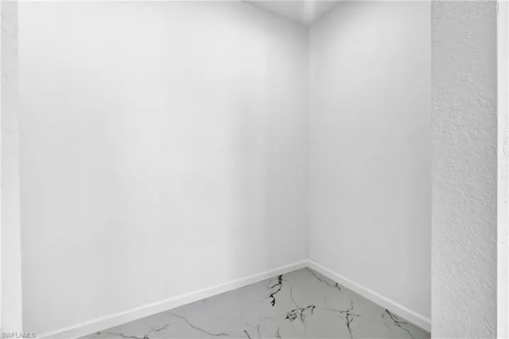 Unfurnished room featuring baseboards and marble look tiles