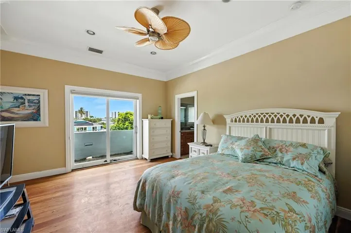 Bedroom with crown molding, light wood-style flooring, access to exterior, connected bathroom, and ceiling fan
