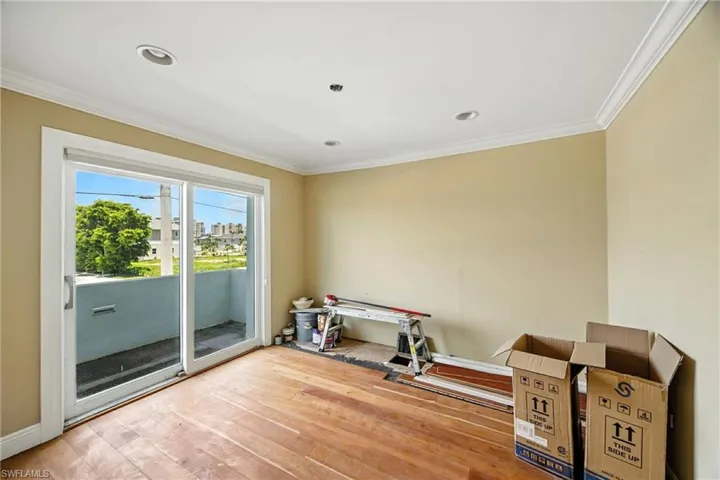 Workout area featuring crown molding and hardwood / wood-style flooring