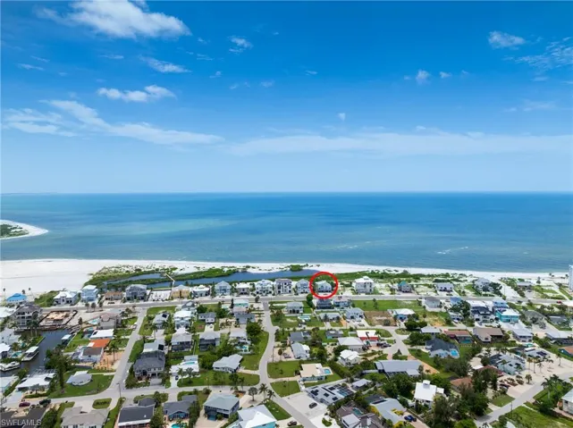 Aerial view of property's location featuring nearby suburban area and extended coastline