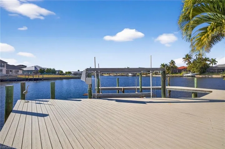 Dock featuring a water view, boat lift, and a residential view