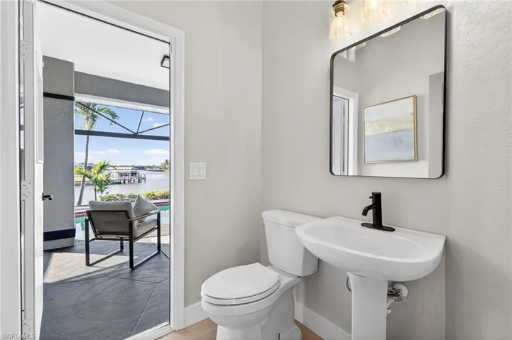 Half bathroom with a water view and a textured wall