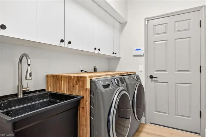 Laundry area featuring cabinet space, light wood-type flooring, and washer and dryer