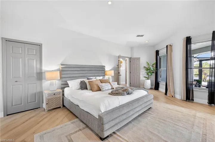 Bedroom with light wood-style floors, recessed lighting, and a closet