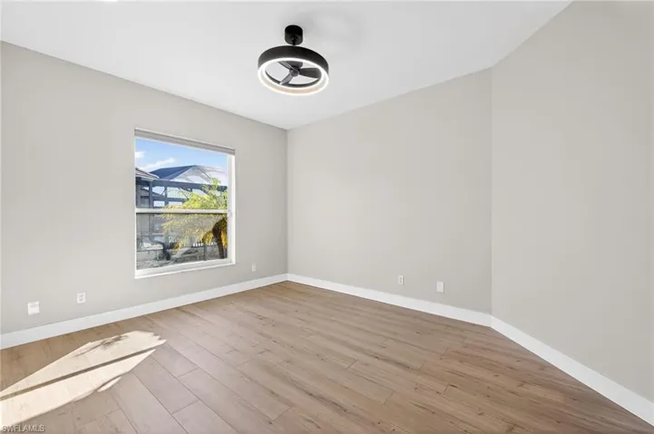 Empty room featuring light wood finished floors and a ceiling fan